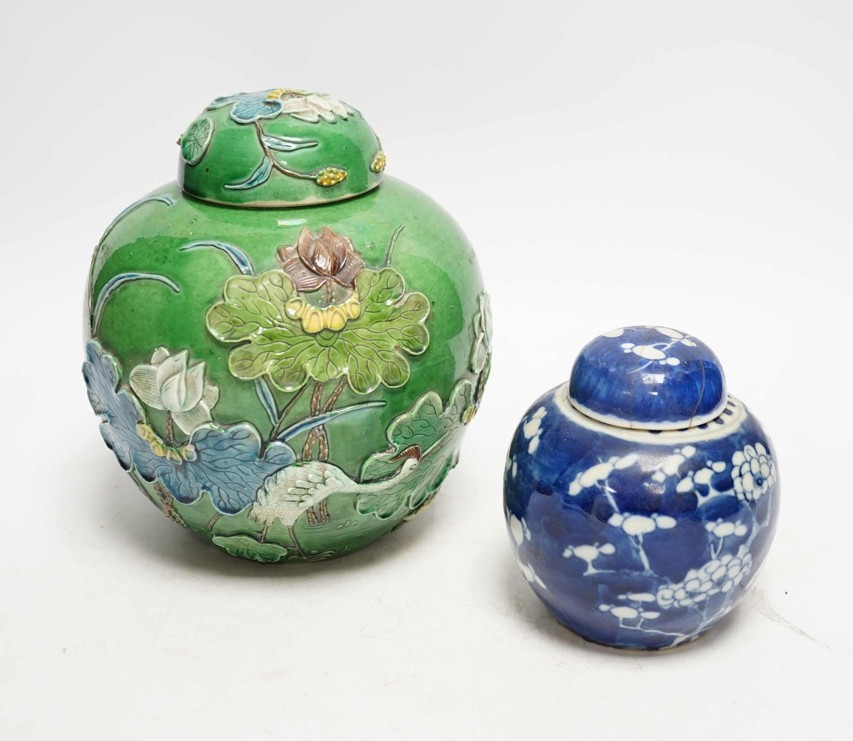 Two Chinese lidded ginger jars, one with applied decoration and the other with blue and white prunus decoration, tallest 18cm. Condition - fair, one lid restored